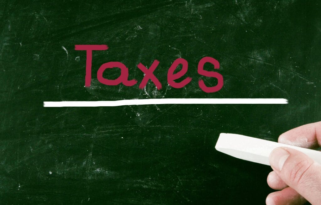 Chalkboard with the word 'Taxes' written in red, highlighting the importance of understanding tax implications when selling your Columbus home