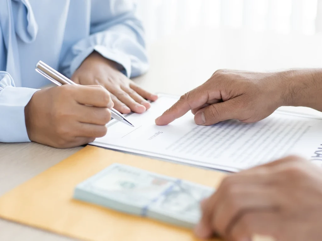 Columbus Ohio homeowner reviewing a cash offer contract and bank statement to spot a fake cash offer